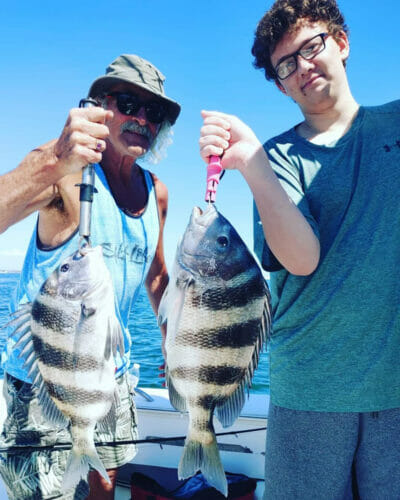 Two anglers holding sheepshead from a Pensacola fishing charter with Captain Austin